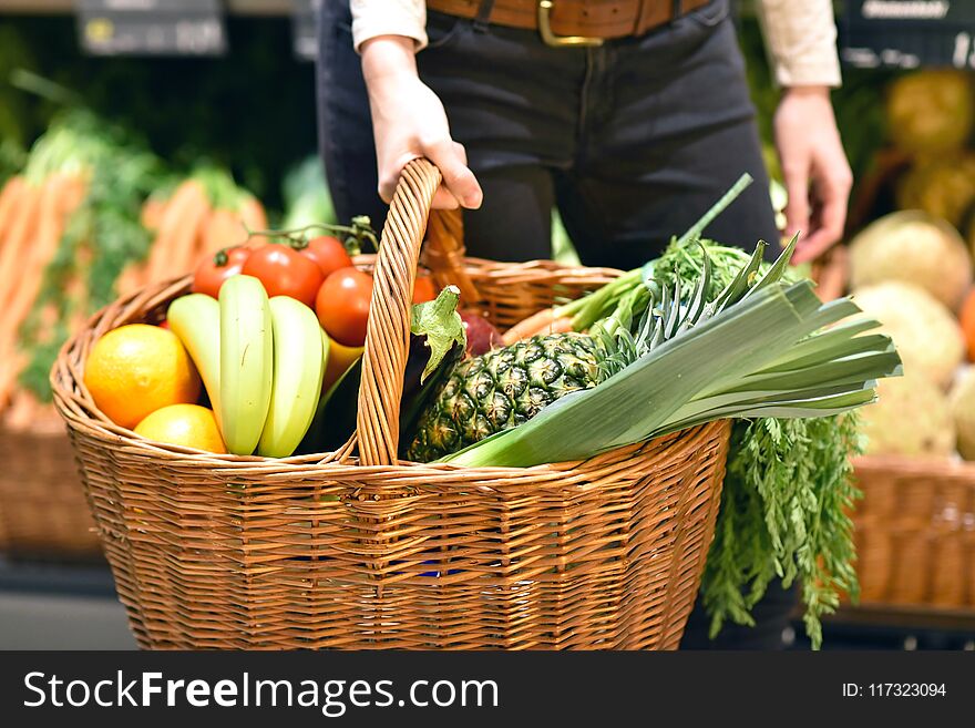 Grocery shopping in the supermarket - filled shopping trolley with fresh fruit and vegetables