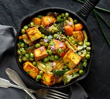 Tofu With Vegetables Sprinkled With Herbs And Edible Flowers, Top View. Vegan Dish Delicious And Nutritious. Stock Photo