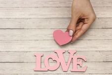 A Female Hand Holds A Wooden Heart, The Concept Of Love Royalty Free Stock Photography