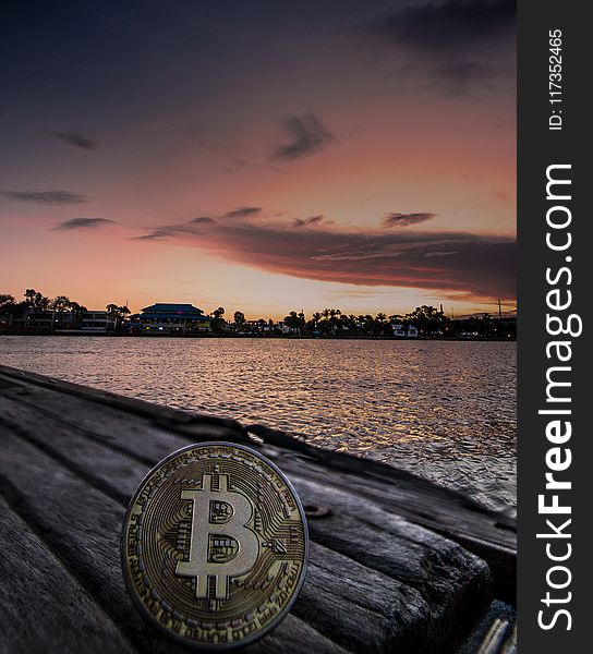 Body Of Water During Dawn With Bitcoin Logo Text Overlay