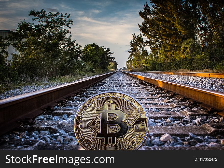 Gold-colored Bitcoin on Railroad