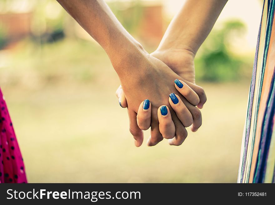 Shallow Focus Photography Of Two Person Holding Hands