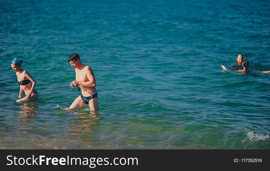 People Swimming On Body Of Water