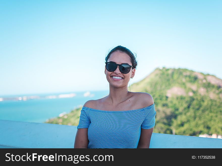 Smiling Woman Wearing Grey Striped Off-shoulder Top And Black Sunglasses