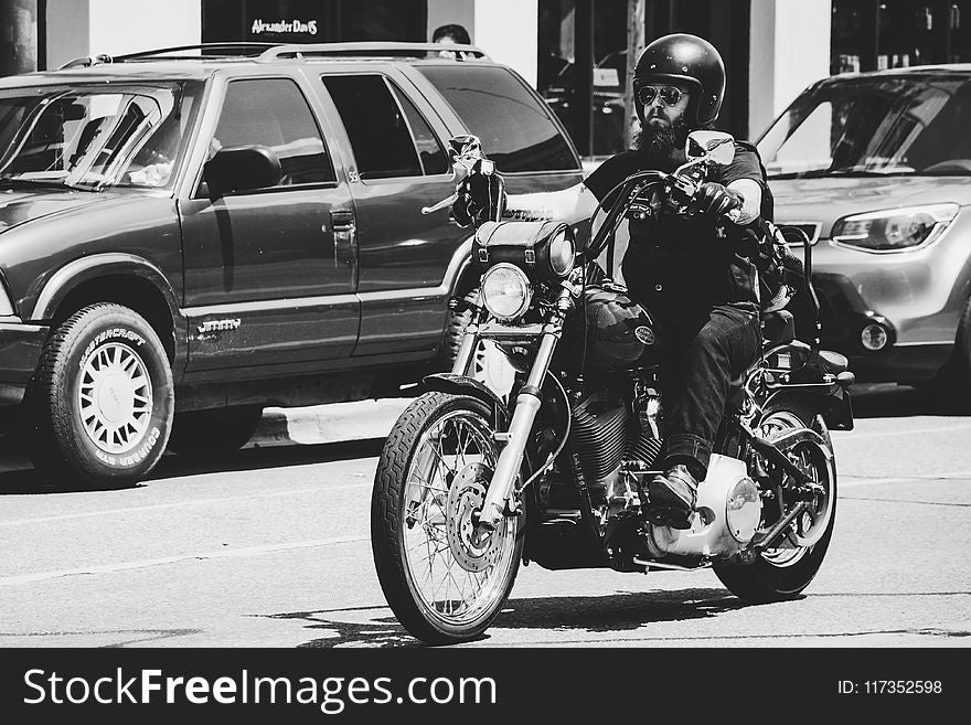 Greyscale Photo Of Man Riding Motorcycle