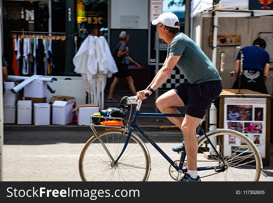 Man Wearing Grey T-shirt Riding Bicycle