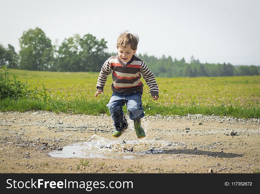 Boy Jumping Near Grass At Daytime