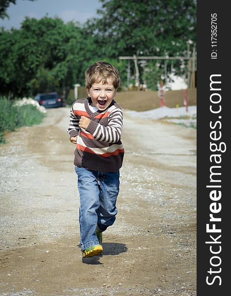 Boy Wearing Red, Brown, and White Stripe Sweater Running Photo