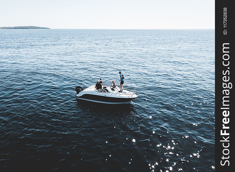 Three Person on White Motorboat at Daytime