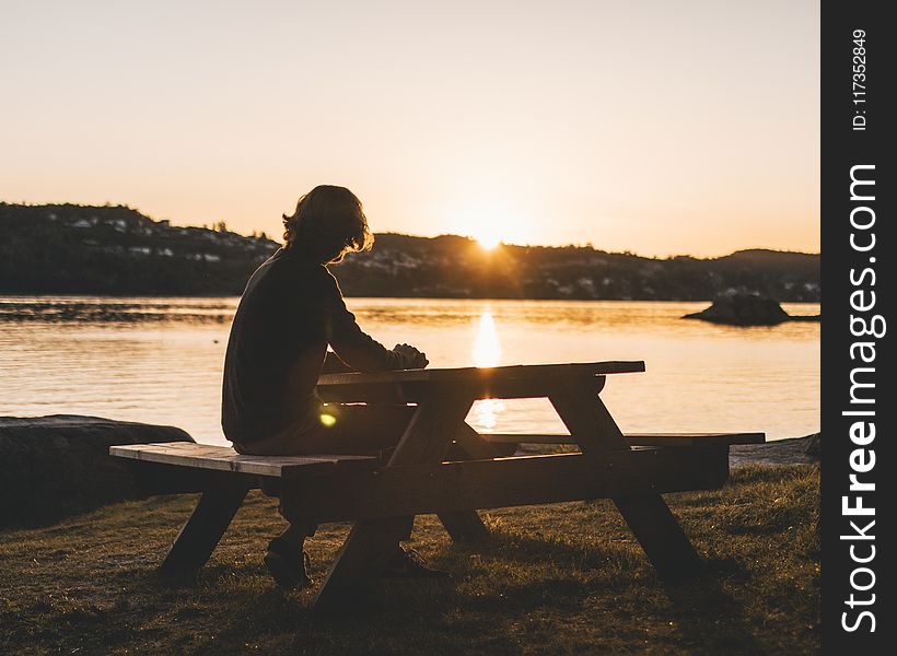 Silhouette of Persons Sitting on Picnic Table