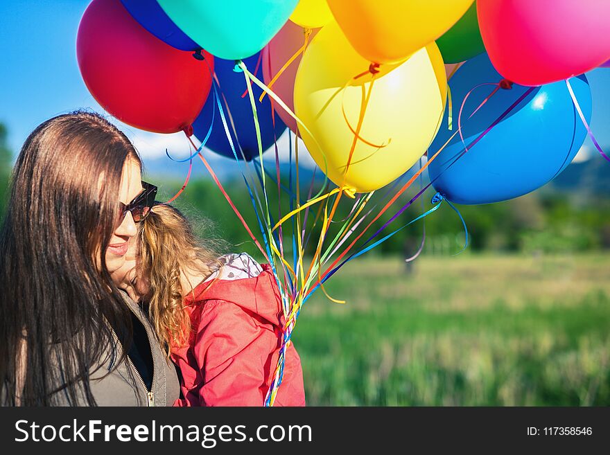 Happy child and mom playing with balloons outdoor. Kid having fun in spring field. Mother`s Day. Happy Mom and baby outdoor. Mother day. Children`s Day or Children Day