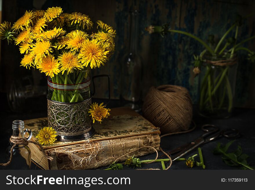 Dandelion flowers on rustic wooden background. Vintage still li