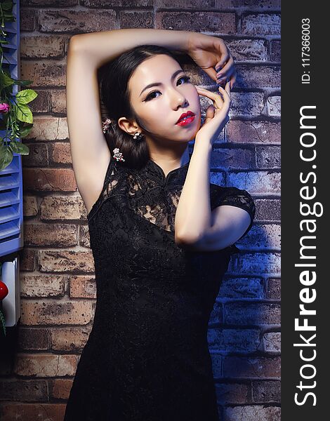 The cheongsam shows the perfect figure of the woman. She showed an attractive gesture. The cheongsam shows the perfect figure of the woman. She showed an attractive gesture.