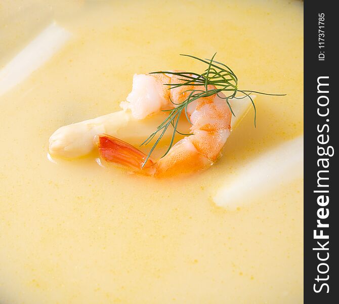 Delicious asparagus cream soup with prawns and fresh dill