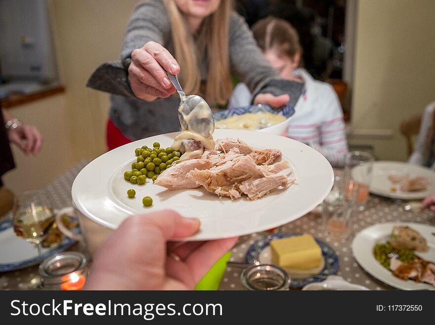 Woman serves food to her family for Thanksgiving. Woman serves food to her family for Thanksgiving.