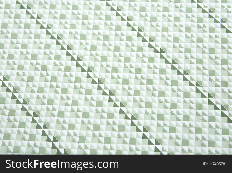 A close up of fabric with patern of greenish triangles