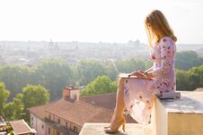 Businesswoman Working On Laptop In Early Morning With City Panorama In Background Stock Image