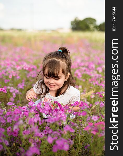 Little Happy Girl In A Purple Flower Field