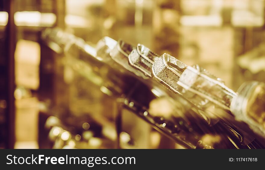 Row of vintage wine bottles in a wine cellar background