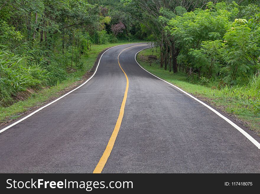 Curve way of asphalt road through the tropical forest in northern Thailand.