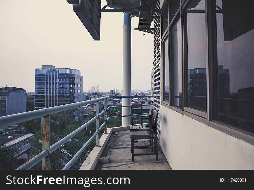 Two Wooden Chairs On Terrace Of Building