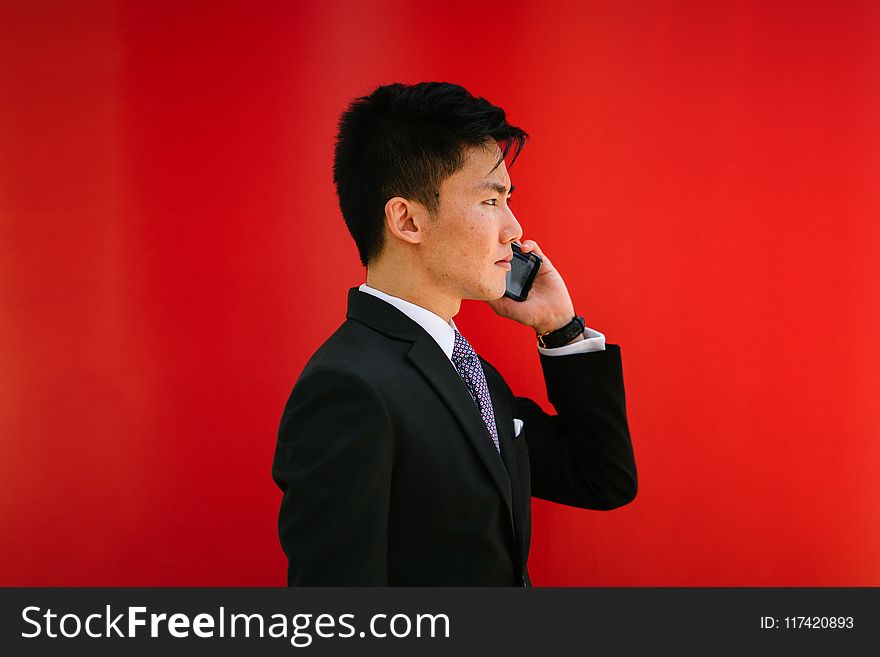 Man Holding Smartphone Wearing Black Notched-lapel Suit Jacket