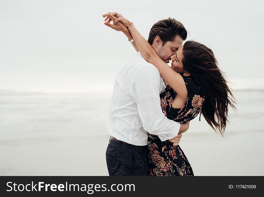 Man and Woman Hugging Each Other Near Body of Water