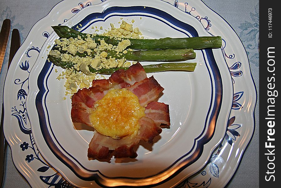 A dish with bacon egg and asparagus. A dish with bacon egg and asparagus