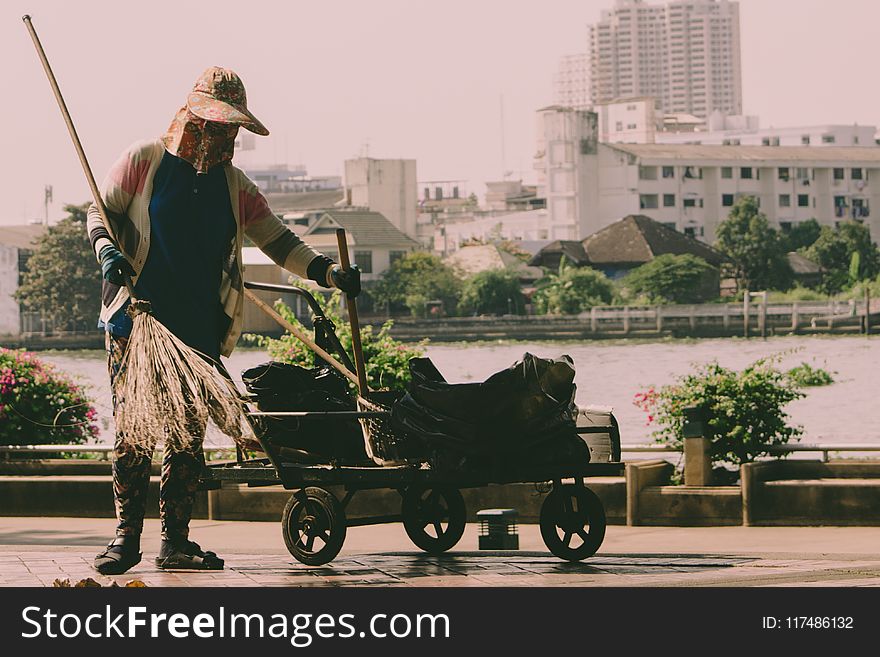 Person Holding Broom And Cart