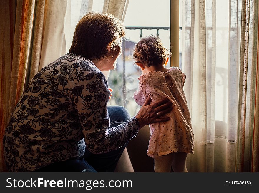 Woman Holding Baby Near Window