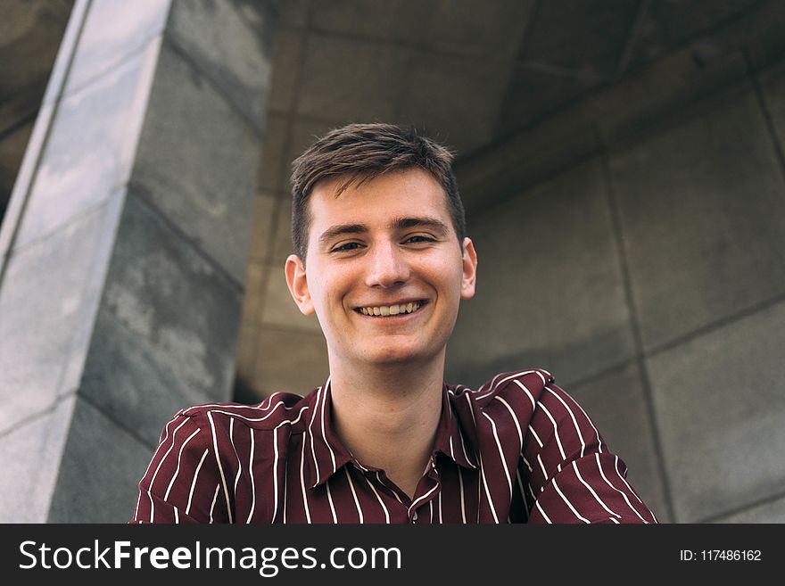 Man in Red and White Striped Collared Shirt Smiling