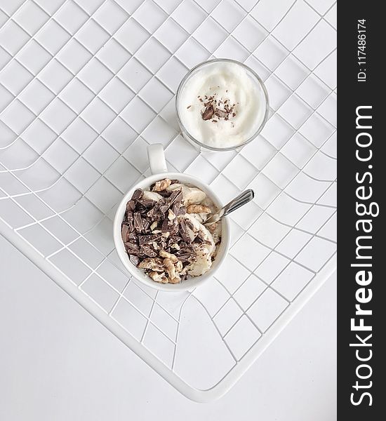 Crushed Nuts and Chocolates on White Ceramic Mug High-angle Photography