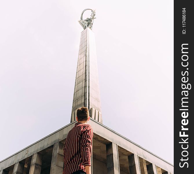 Man Standing in Front of Gray Concrete Tower