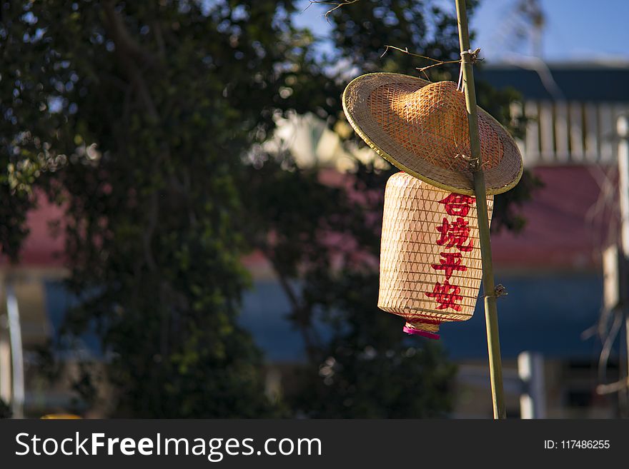 Straw Hat And Paper Lantern Placed On Bamboo Pole