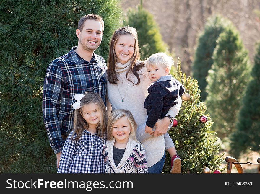 Photography of Family Near Pine Tree