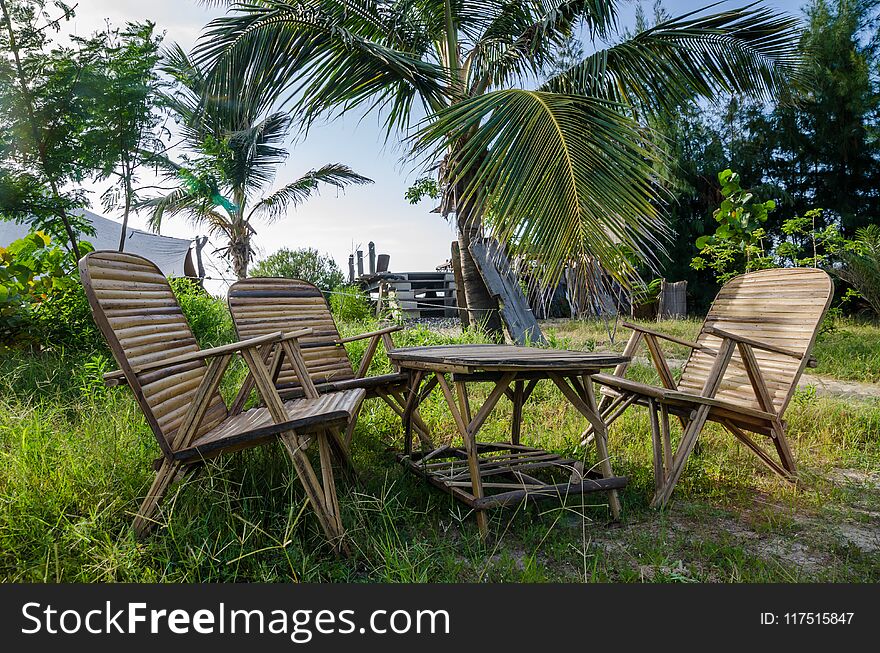 Rustic group of chairs and table made of bamboo in lush green surroundings at coast of Senegal, Africa.