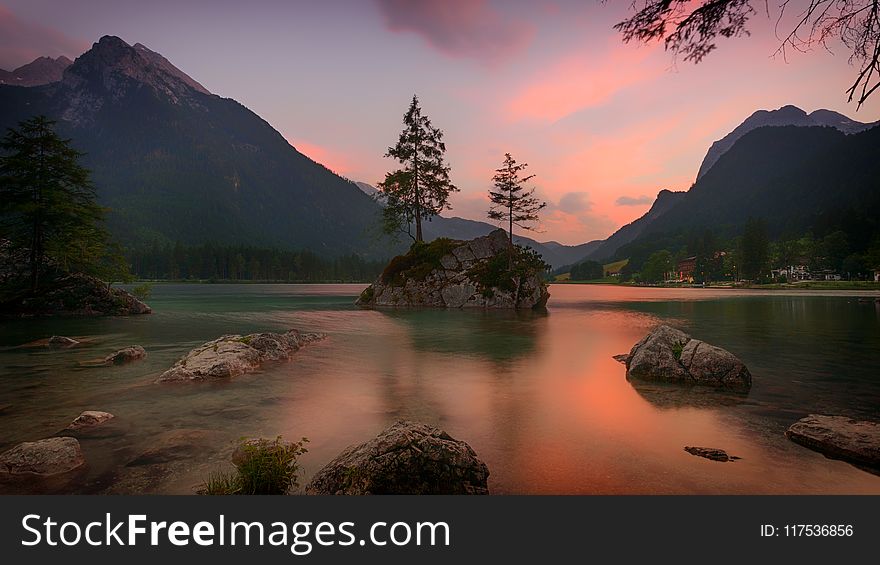 White Rock Formation On Water With Mountain Background