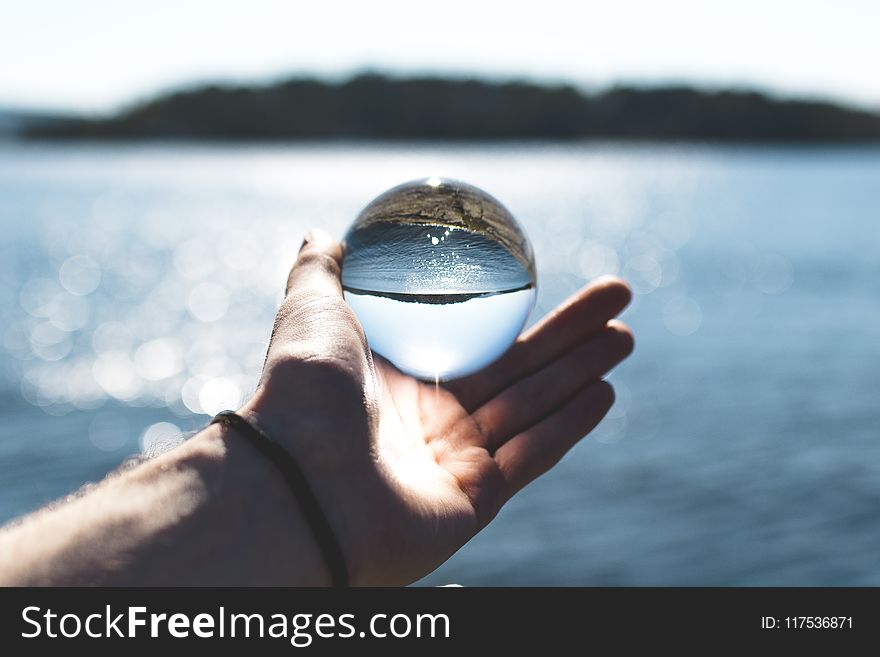 Bokeh Photography Of Person Holding Water Drop