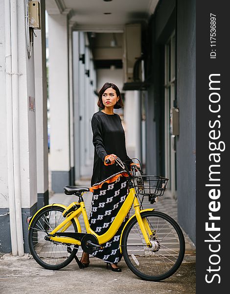 Woman Holding Yellow Bike at Daytime