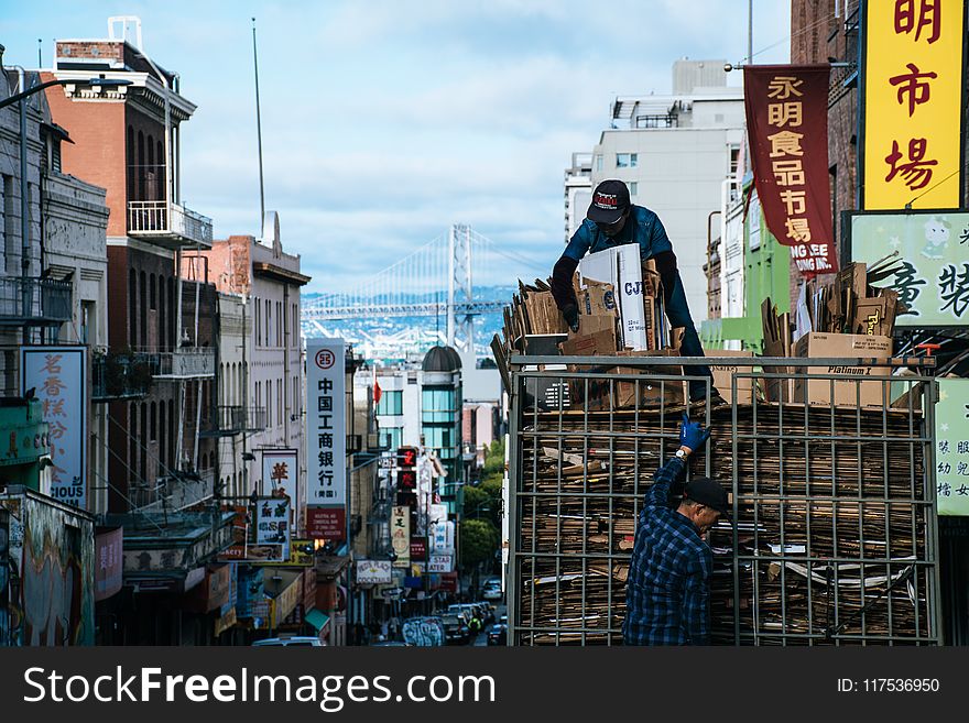 Man On Top Of Truck Arranging Brown Cardboard Boxes