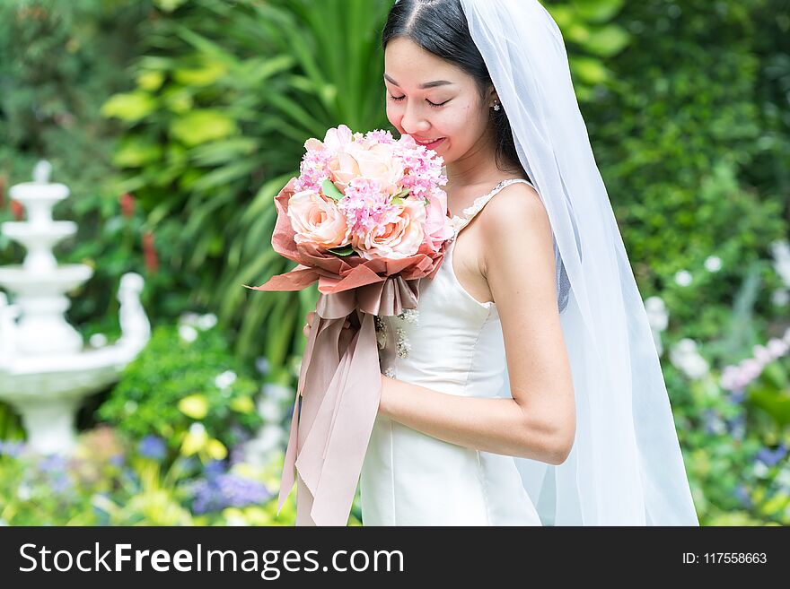 Bride holding a bouquet in the garden.