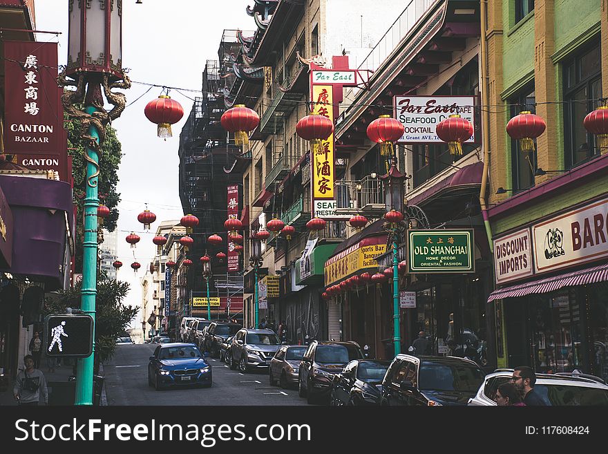 Vehicles Parked Beside Buildings Under Red Chinese Lanterns