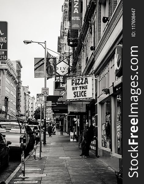 Grayscale Photography of Pizza by the Slice Signage