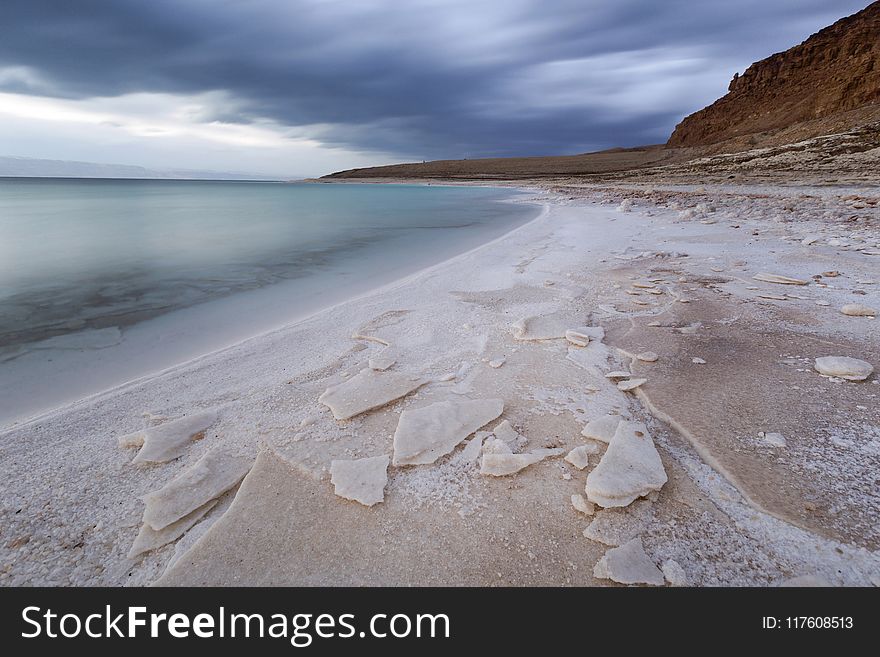 Body of Water Beside Mountain