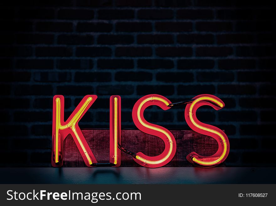 Red Kiss Neon Light Signage on Dark Lit Room