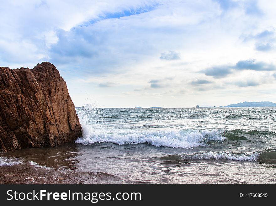 Sea Waves Splashing on Shore and Rock Island