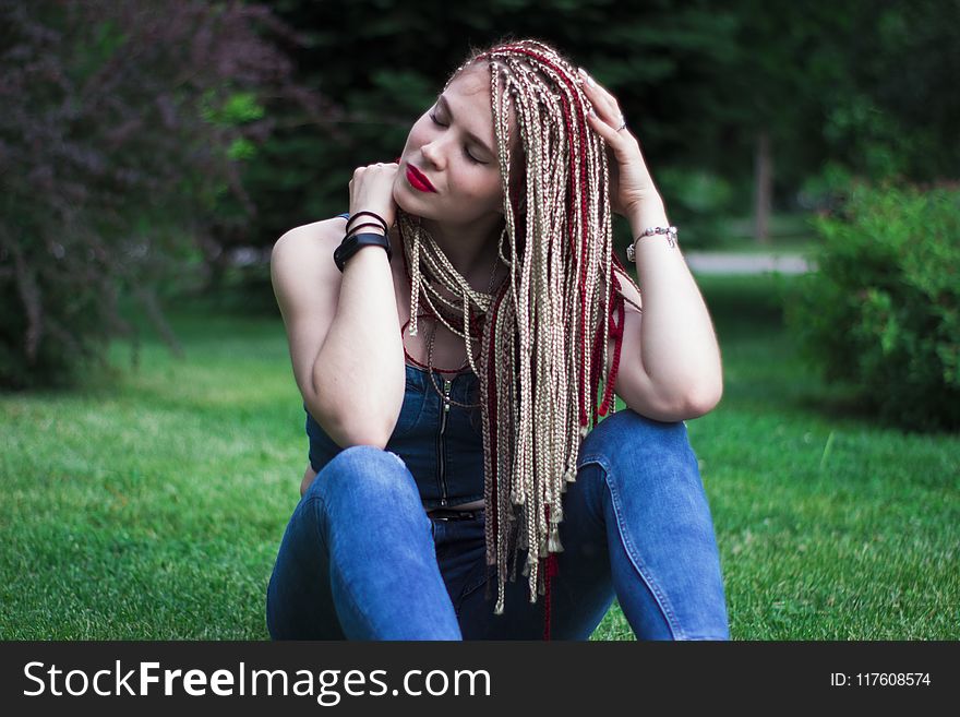 Woman in Blue Sleeveless Top and Blue Jeans