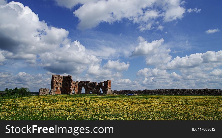 Brown Wall On Green Field Under Clouds