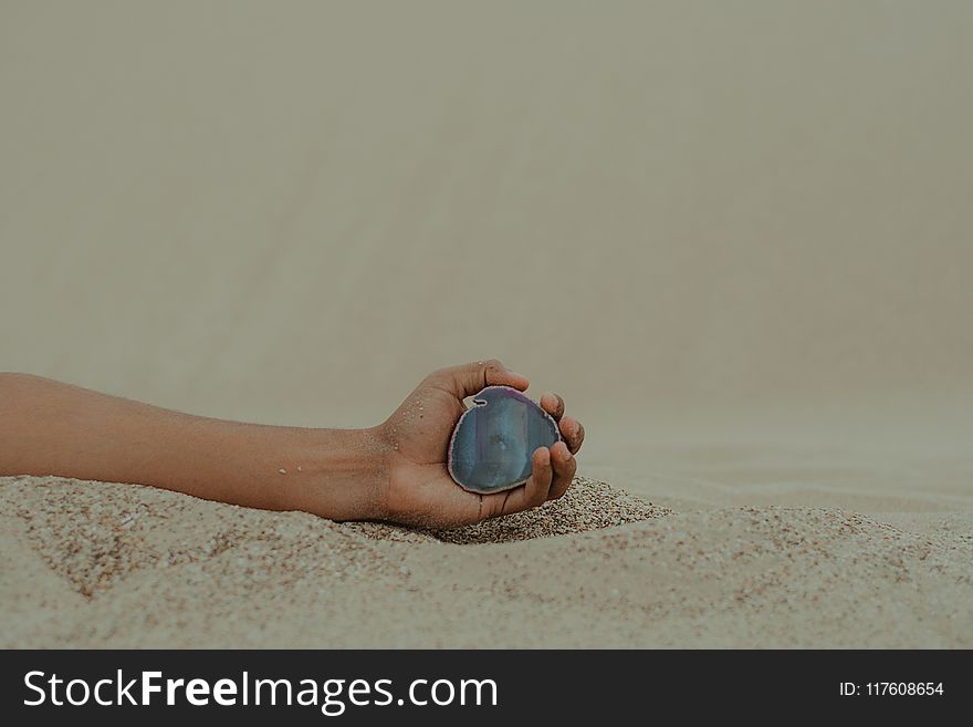 Person Holding Gemstone on Seashore