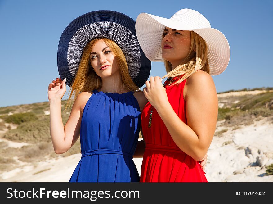 Blond women in the red and blue dresses at the beach in Cyprus.